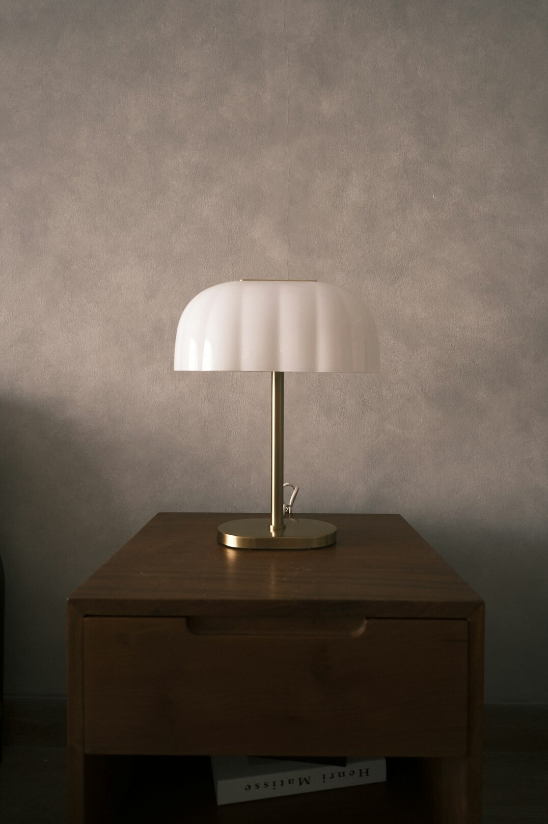 Open book beside a lamp on a wooden desk