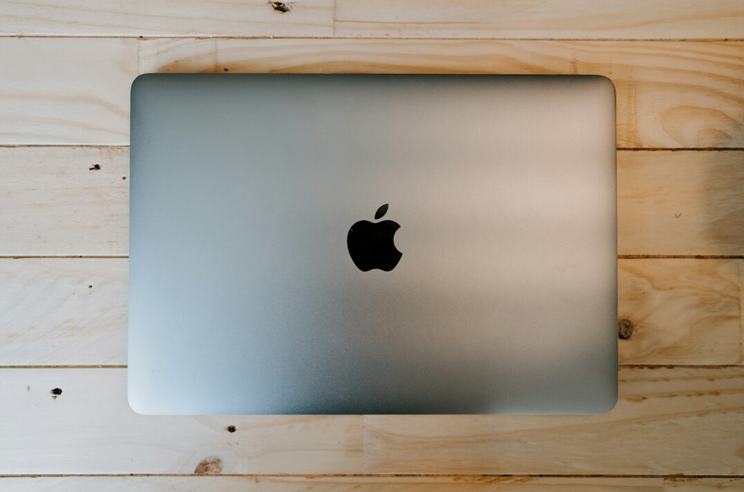 Laptop screen with lines of text on a dark desk